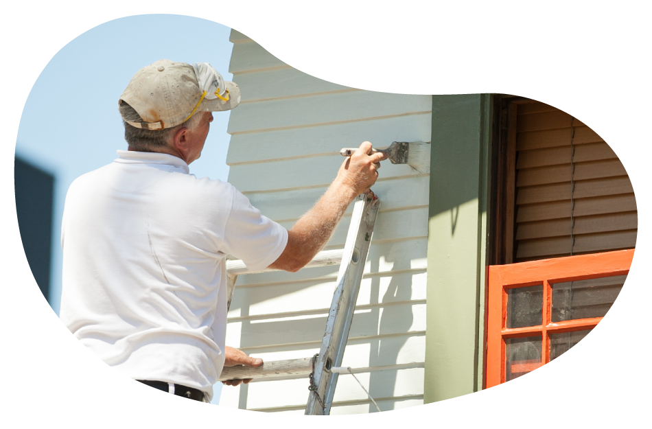 Painter applying a coat of paint onto an exterior wall.