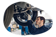 A mechanic works on a customer's car elevated on a lift.