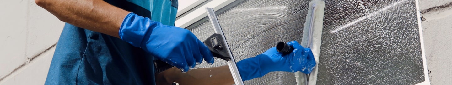 A window cleaner employee washing a window. A window cleaner employee washing a window.