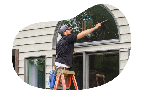 A window cleaner employee washing a window. A window cleaner employee washing a window.