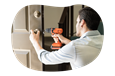 A handyman installing a doorknob at a client's property