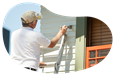 Painter applying a coat of paint onto an exterior wall.