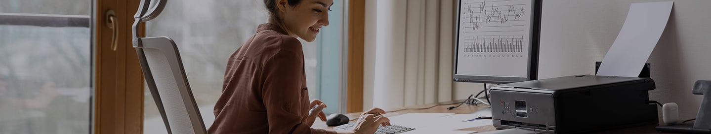 A woman calculating her business's numbers on the computer A woman calculating her business's numbers on the computer